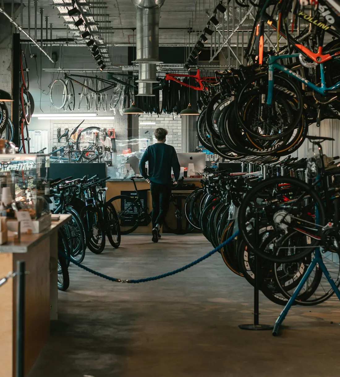 Rows of road bikes in a bike shop showroom, with the service counter at the back
