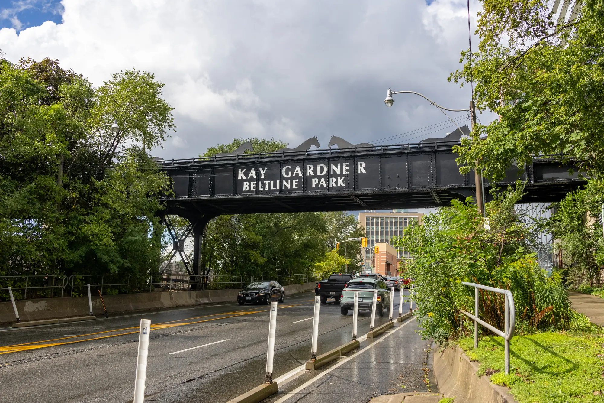 The Kay Gardner Beltline Park bridge over a road, framed by green trees